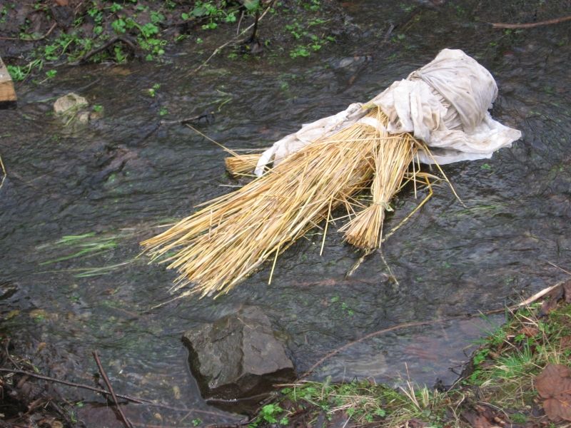 śmiertecka - słomiana kukła kobiety z głową owiniętą białym materiałem leżąca na wodzie